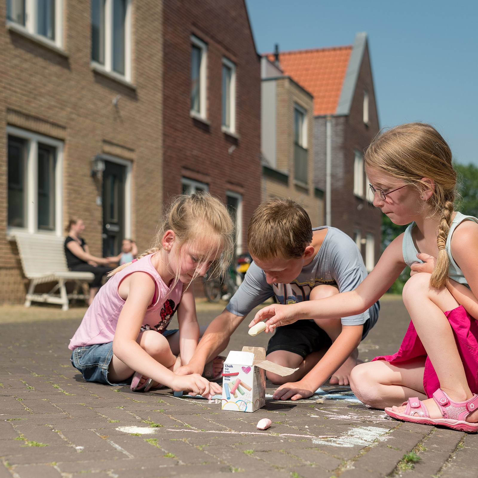 Krijtende kinderen op straat in Hindeloopen